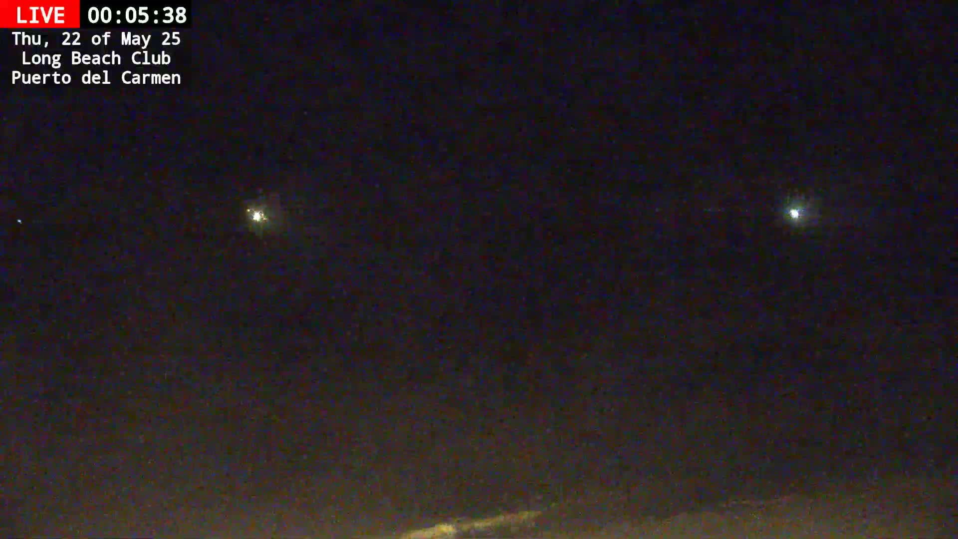 A nighttime, outdoor scene shows a dark sky with several distant lights visible.