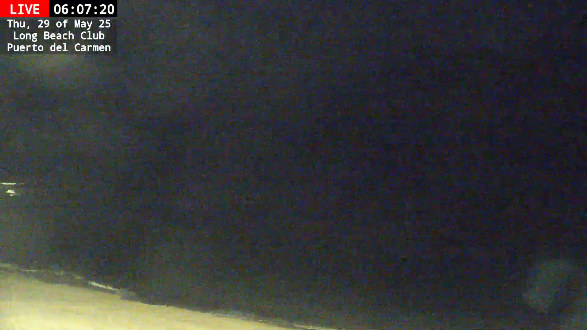 A dark, nighttime beach scene is shown with a dark, possibly cloudy sky.