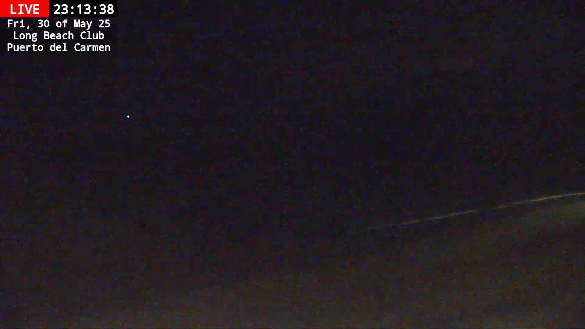 A nighttime long shot shows a dark, mostly clear sky with a faint light source visible in the distance, and a slightly brighter horizon line.