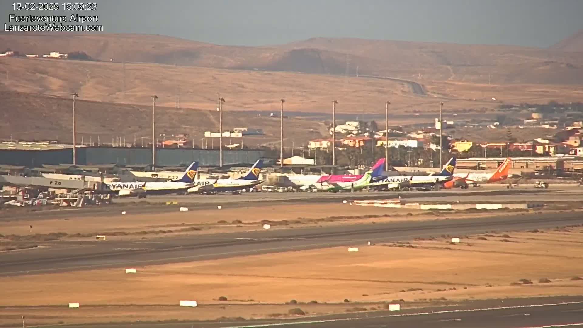 Several airplanes are parked on a tarmac at an airport under a hazy sky.
