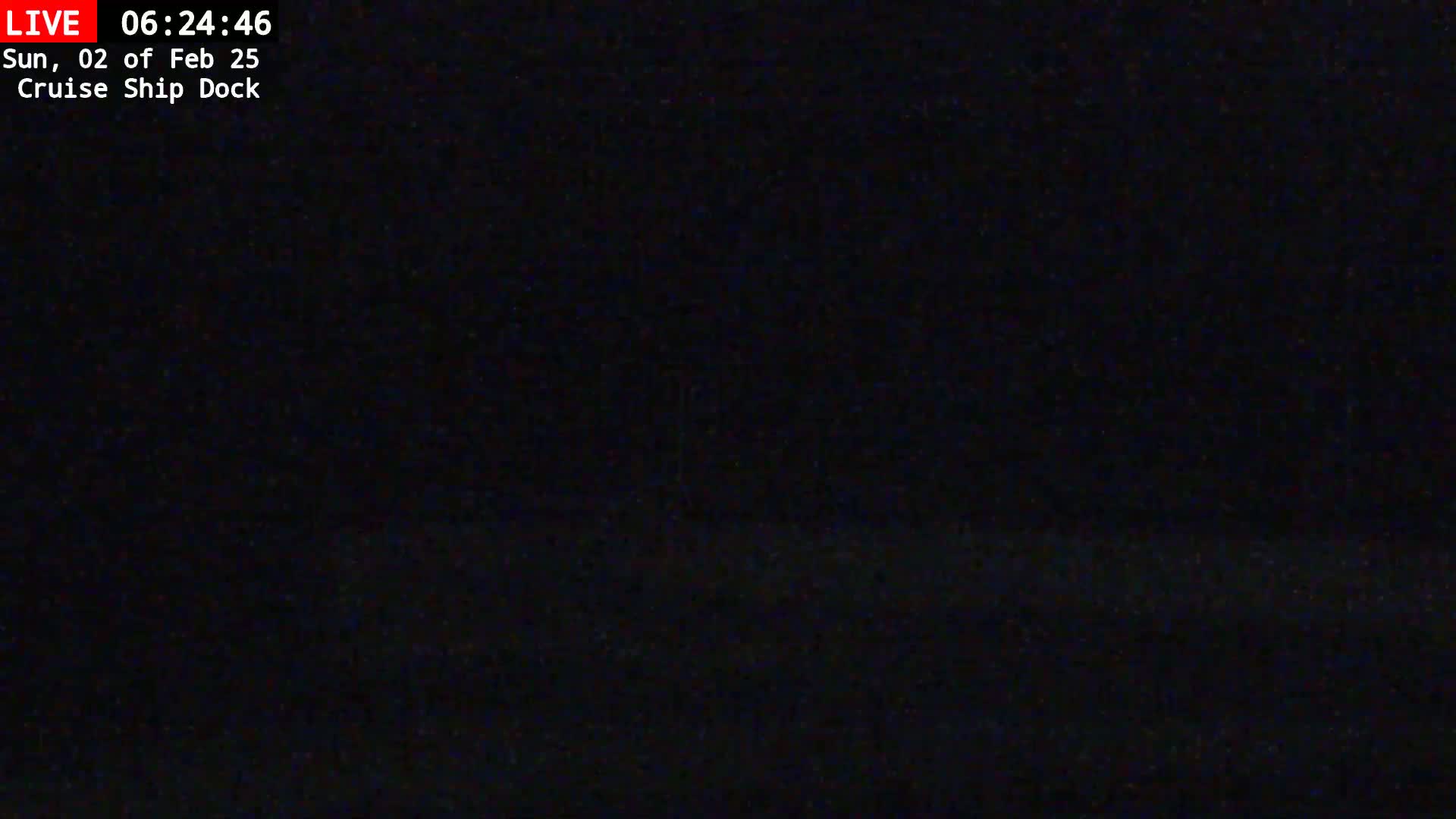 A nighttime view of a dark cruise ship dock under a clear sky.