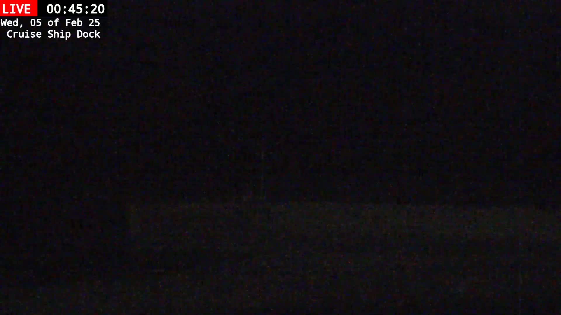 A very dark, nighttime image shows a mostly black scene, possibly of a dock, with a few faint, indistinguishable details.