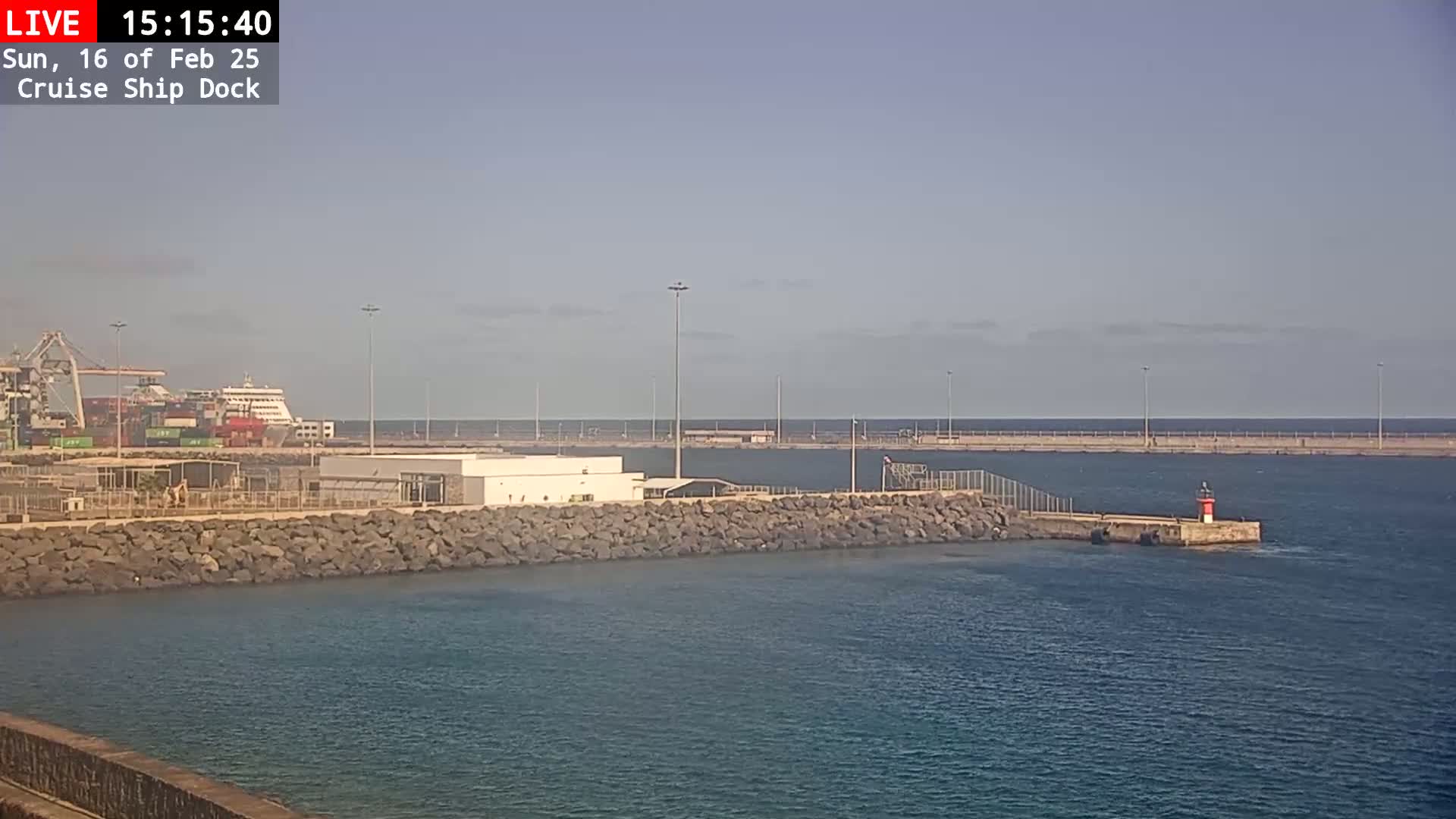 A cruise ship is docked at a port on a partly sunny day.