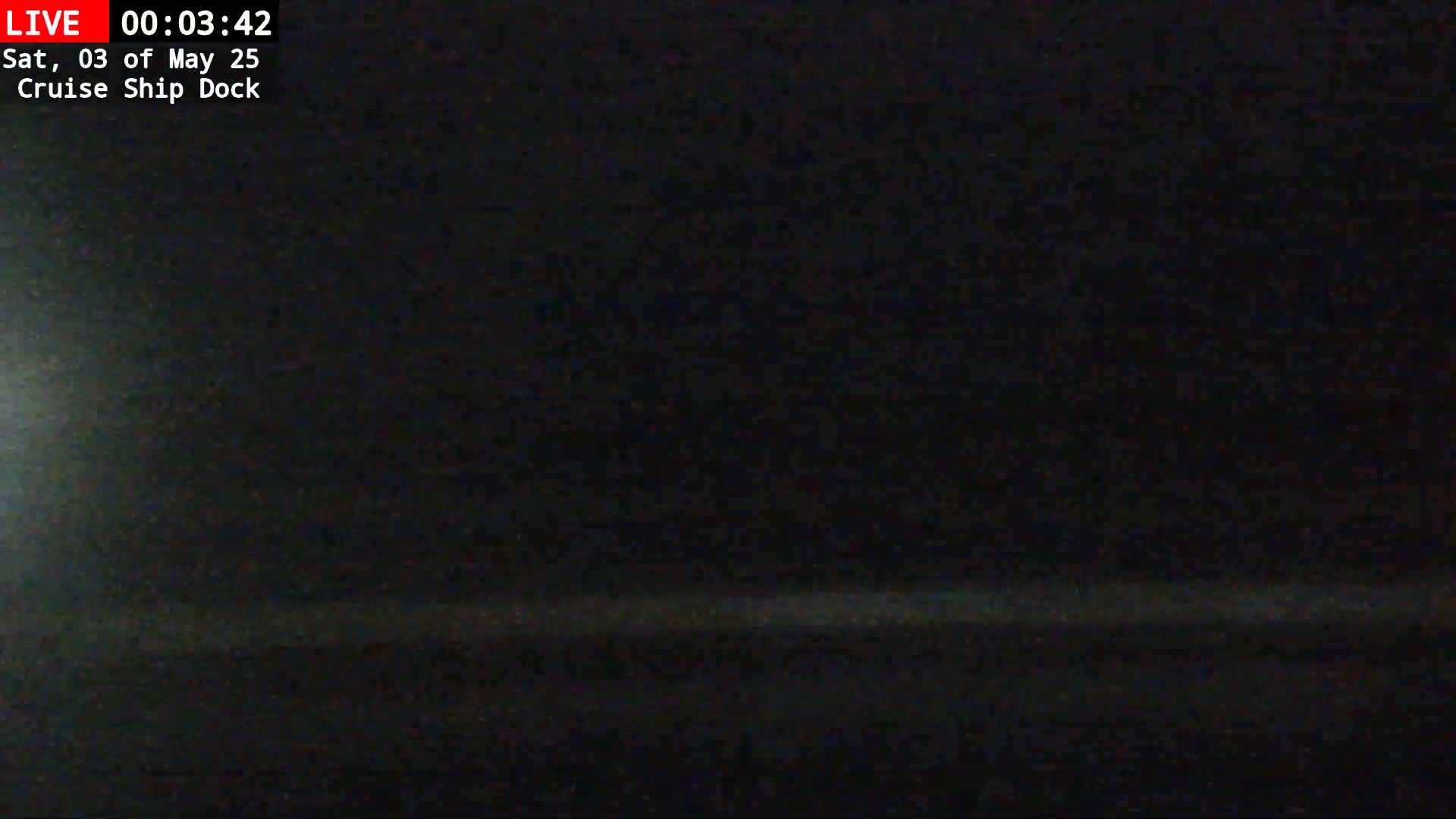 A dark, nighttime view shows a faint, horizontal line near the bottom of the frame, suggesting a low horizon.