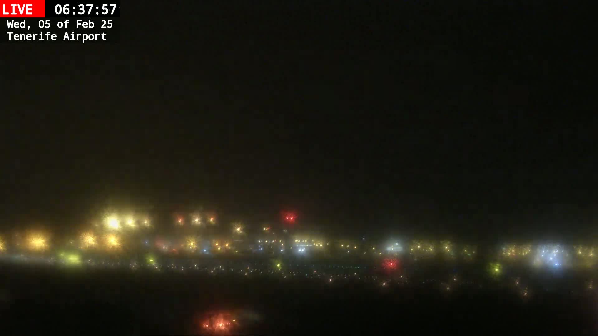 A foggy nighttime view of numerous lights at what appears to be an airport.