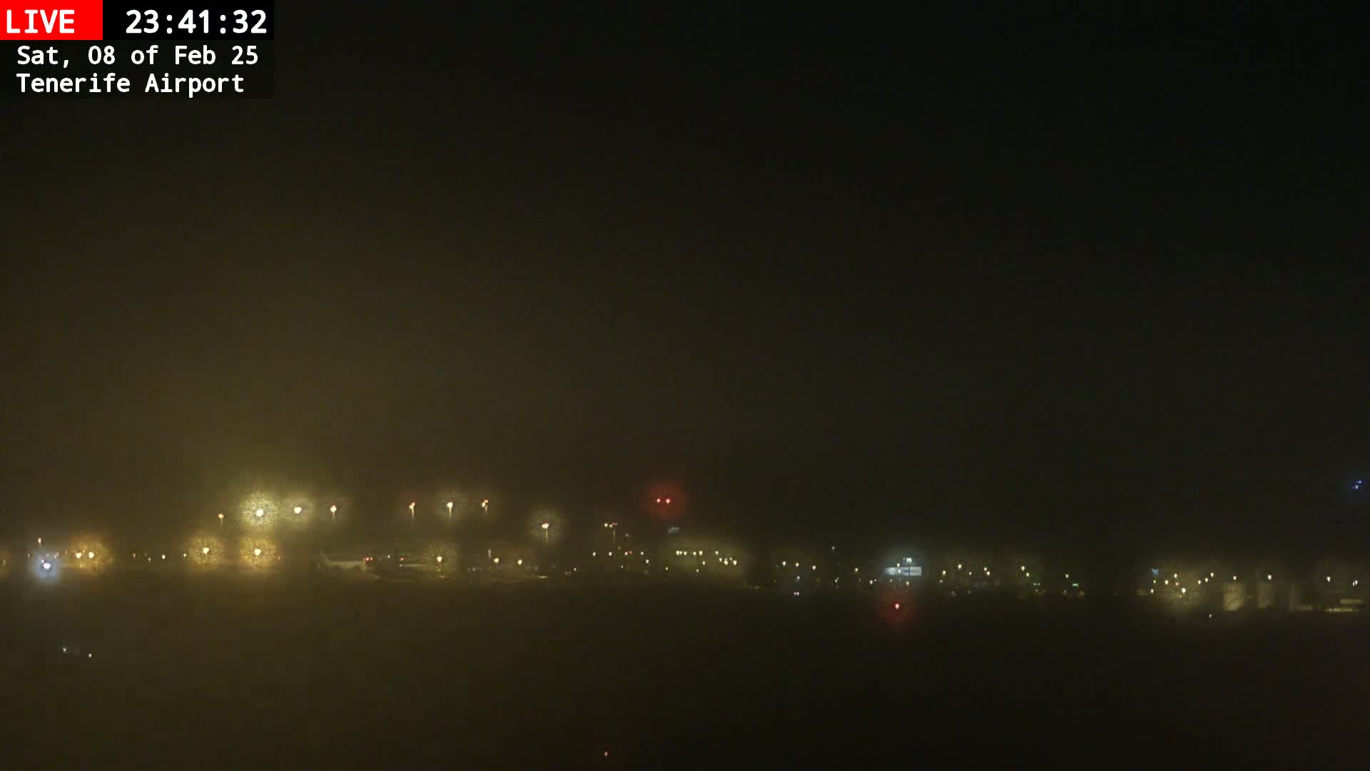 A foggy nighttime view of dimly lit airport grounds.