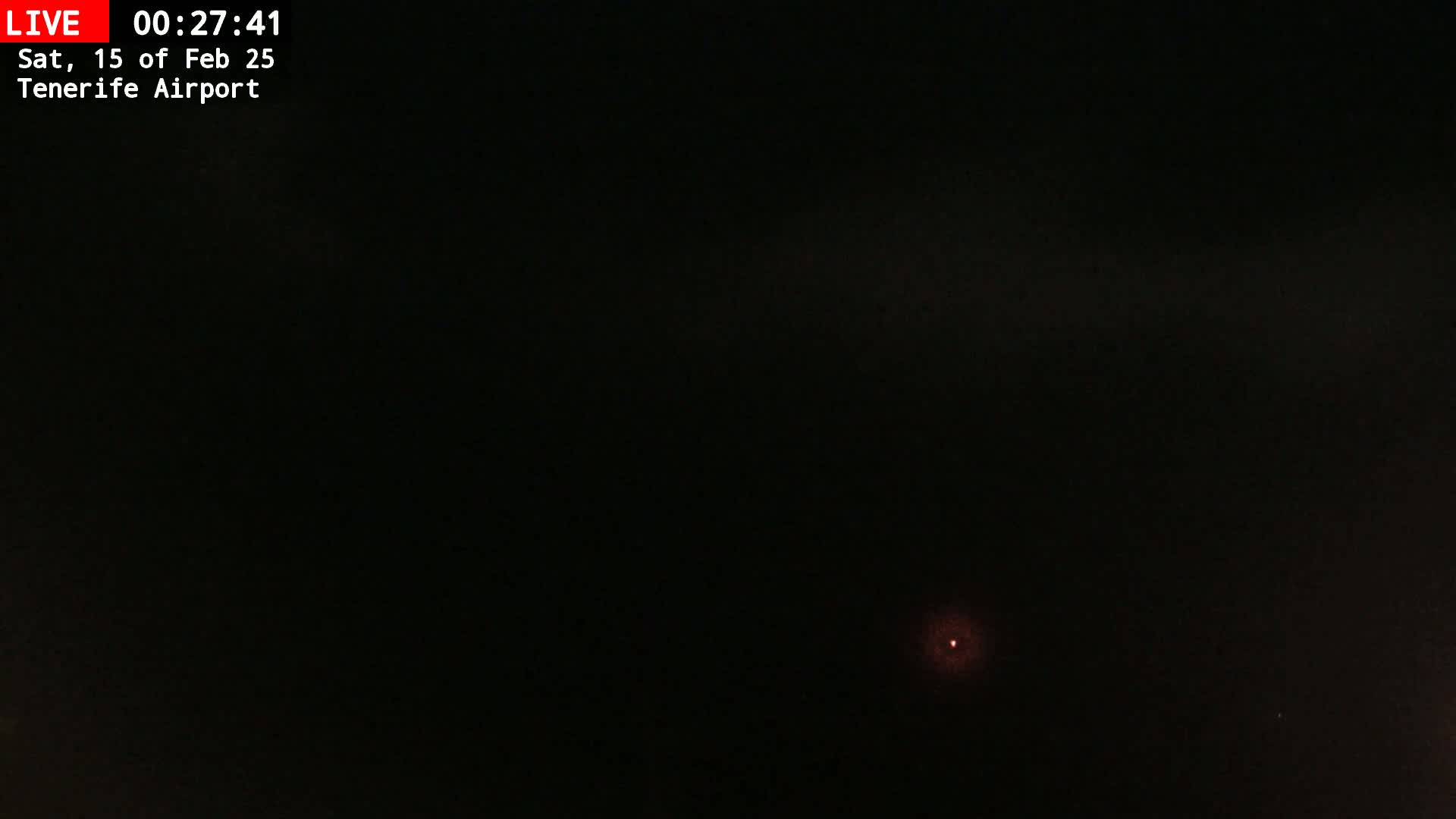 A dark nighttime scene shows a small, faint light in the distance.