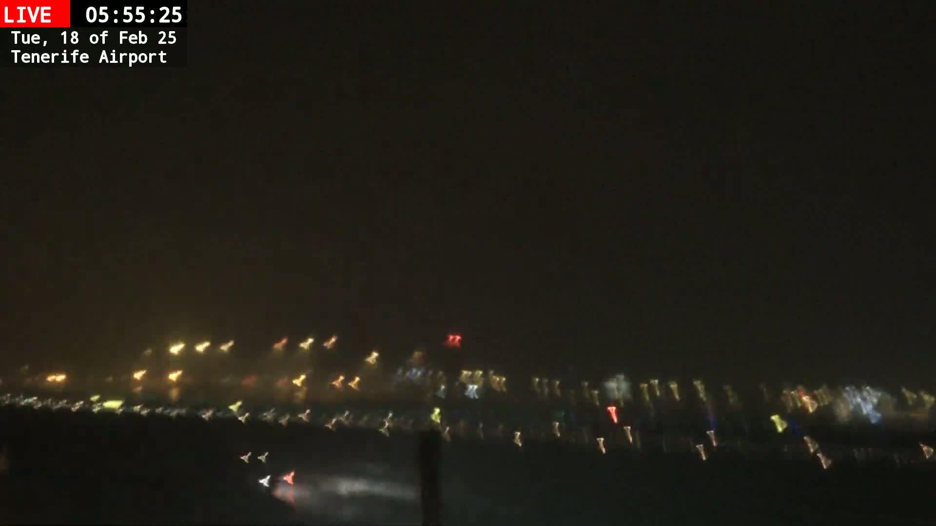 A nighttime view of blurry lights in the distance through hazy or foggy conditions.