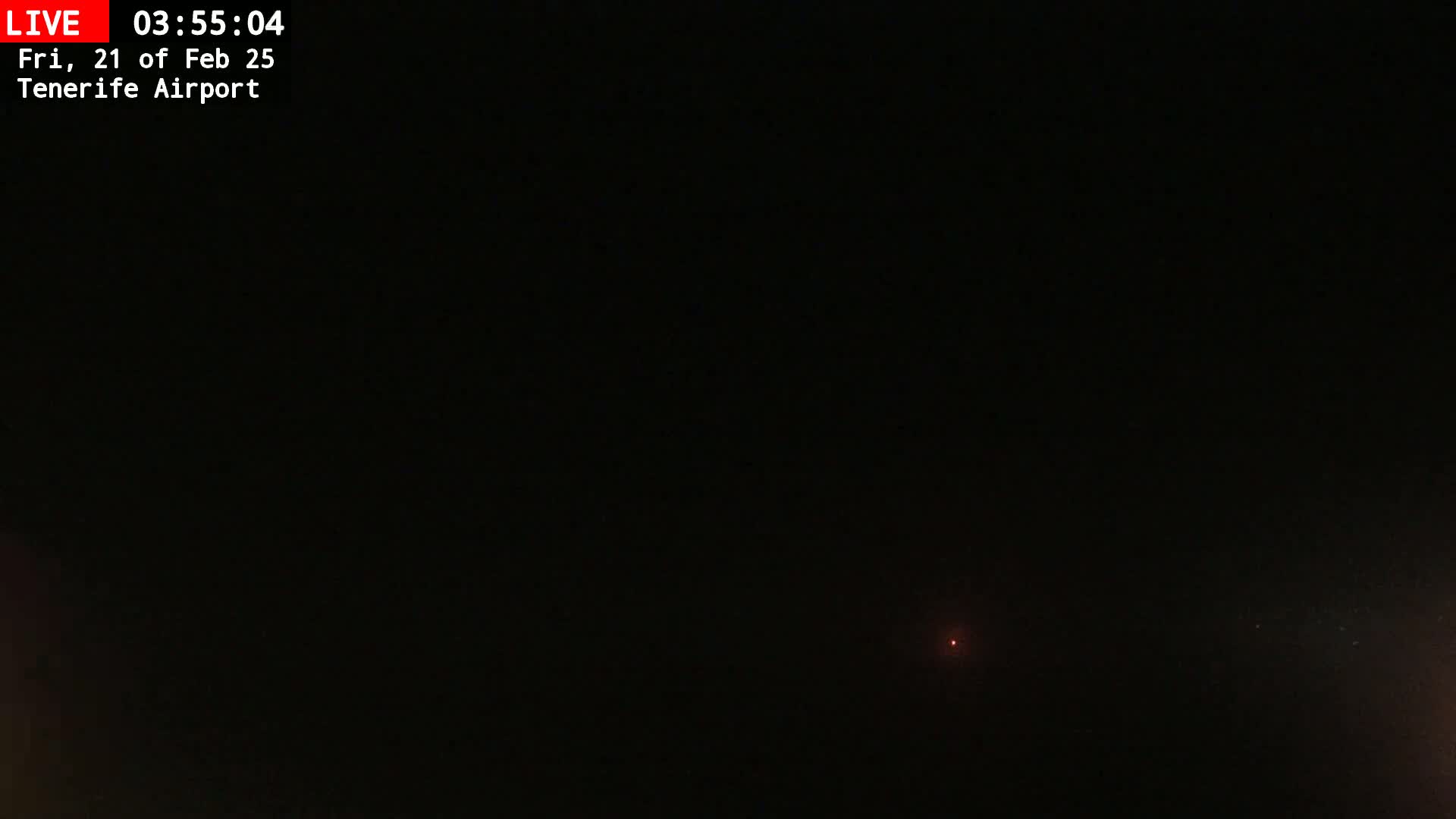A dark, nighttime outdoor scene shows a faint, distant red light.