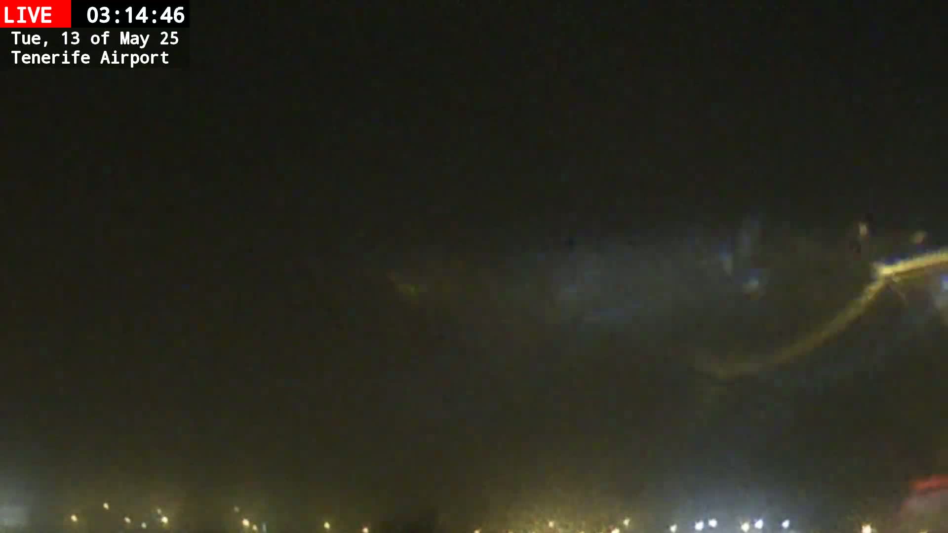 At night, a blurry image shows a low-lying cloud or fog over a dimly lit area with scattered lights in the distance.