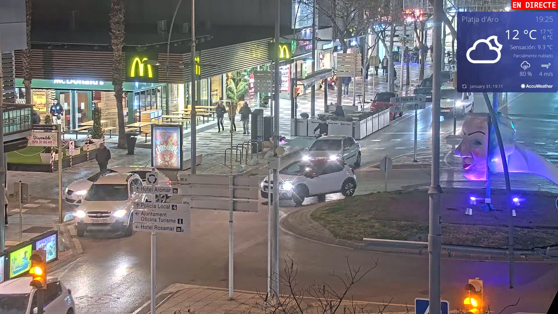 A nighttime street scene shows several cars at an intersection near a McDonald's restaurant under partly cloudy skies with a 4 m/s wind.