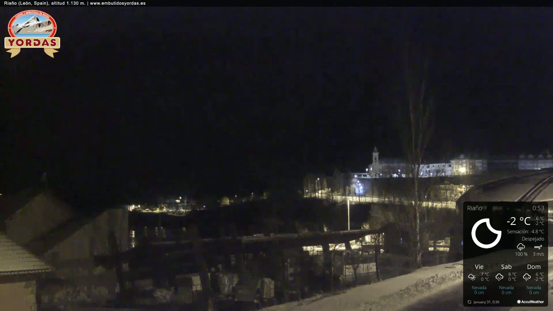 A nighttime view of a snow-covered town under a clear sky.