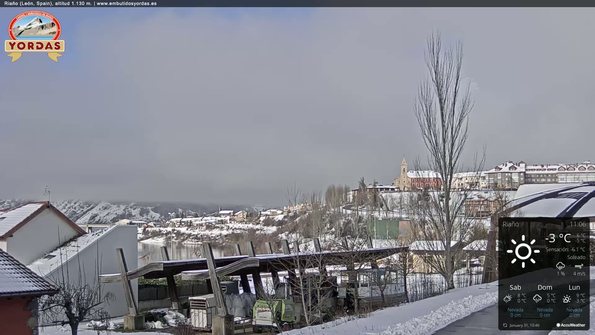 A snow-covered village with a church is visible under a hazy sky.