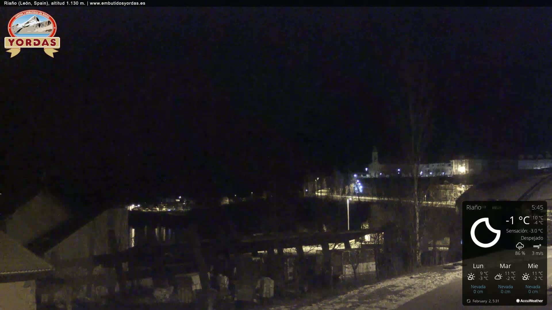 A nighttime view of a snow-dusted town under a clear, dark sky.