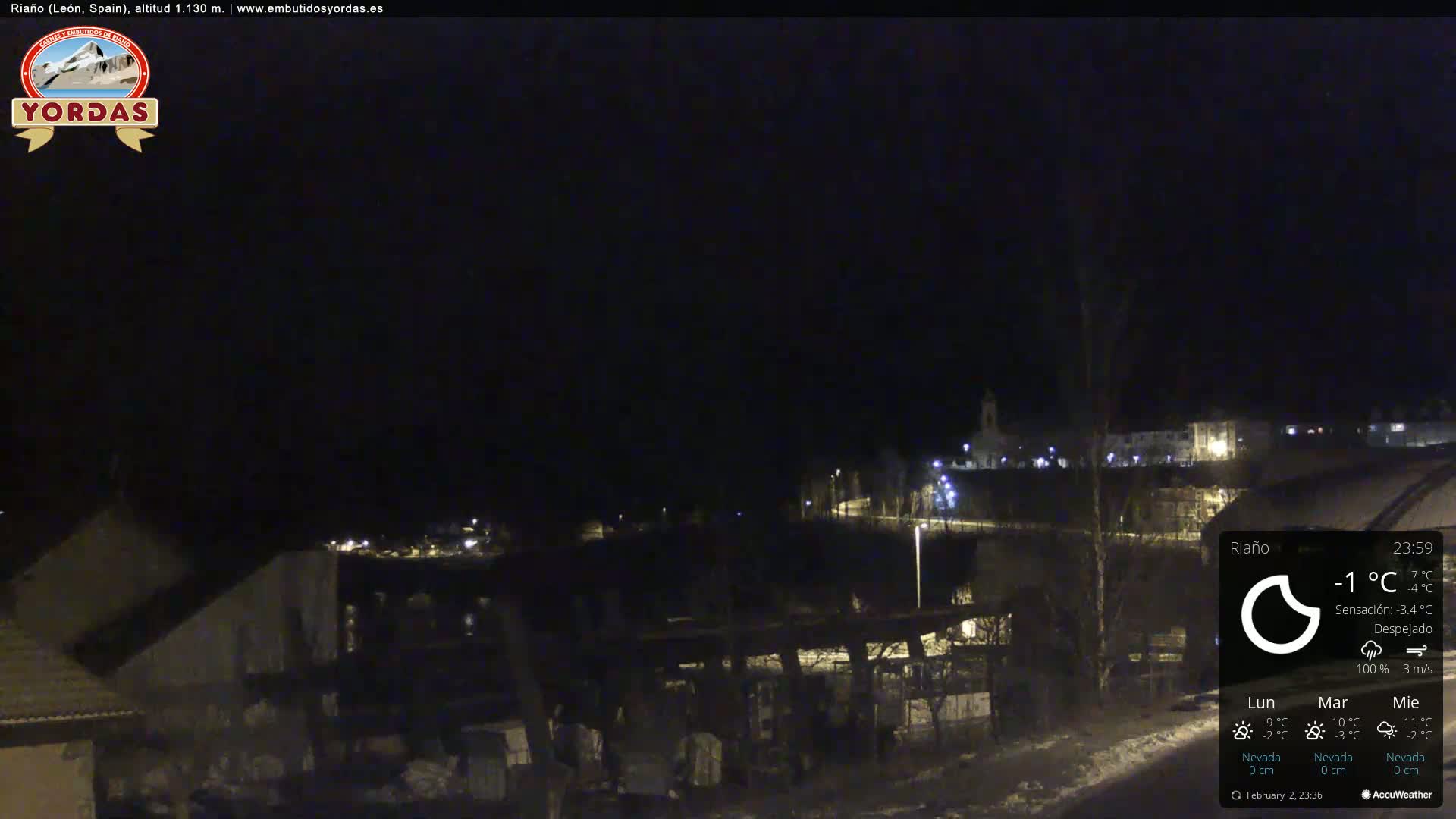A nighttime view of a snow-covered town under a clear sky.