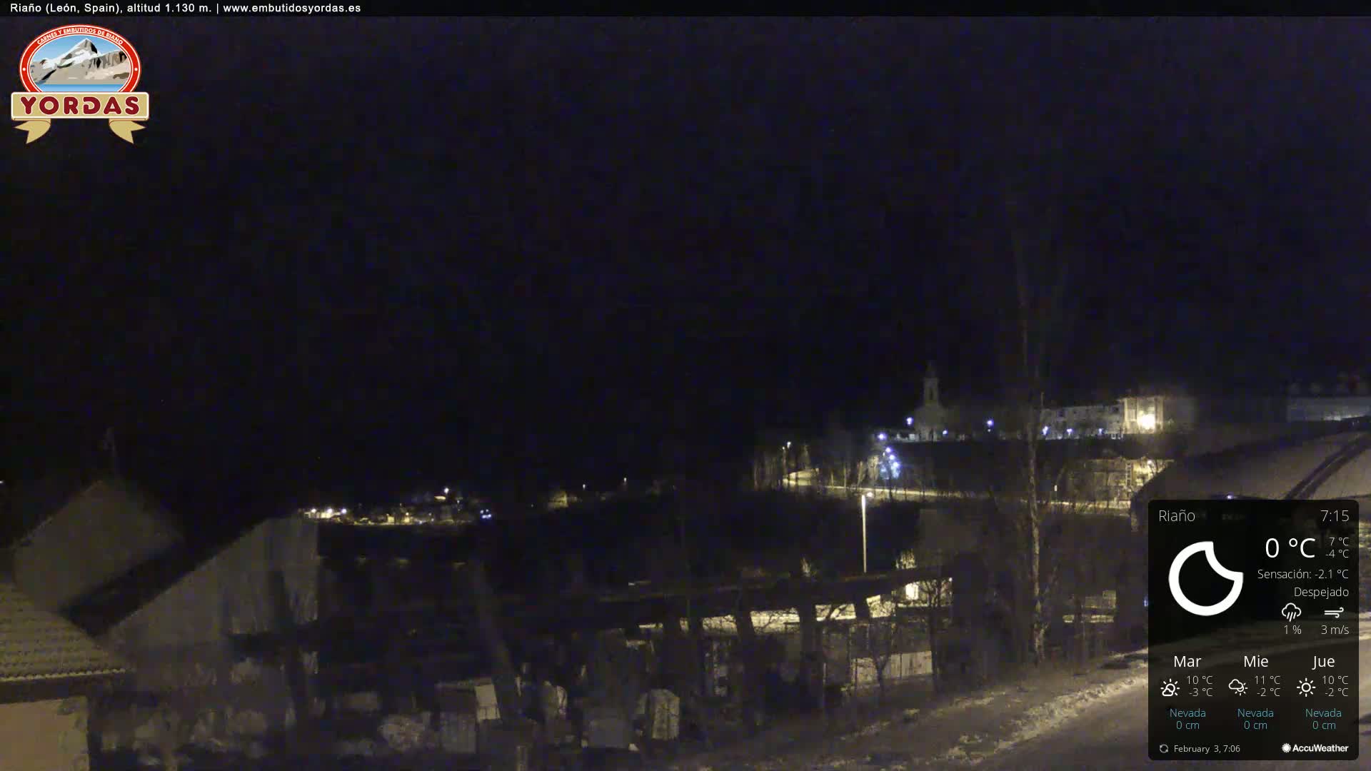 A nighttime view of a snow-covered village under a clear, dark sky.