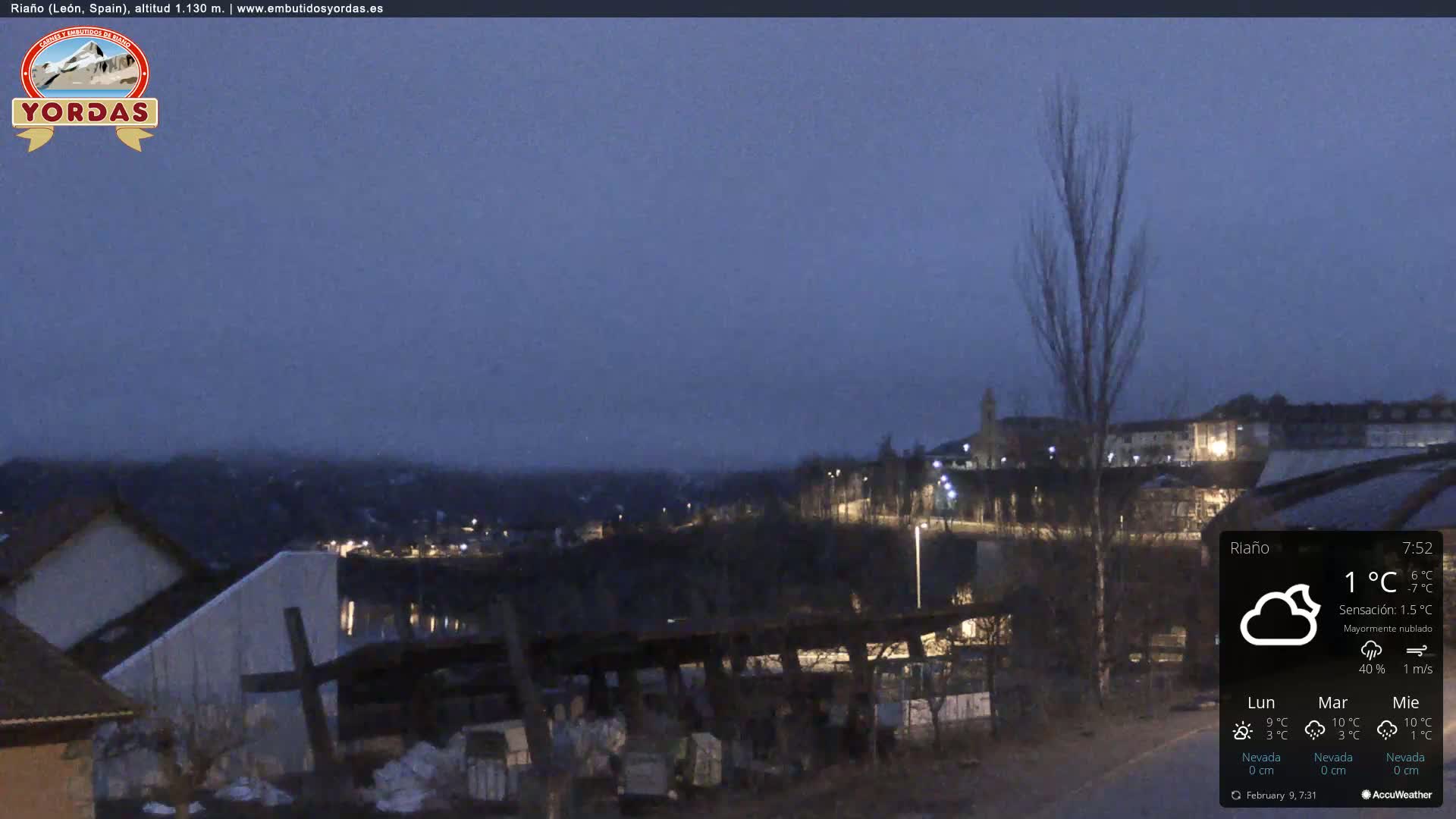 A nighttime view of a town under a mostly cloudy sky with a temperature of 1°C and light winds.