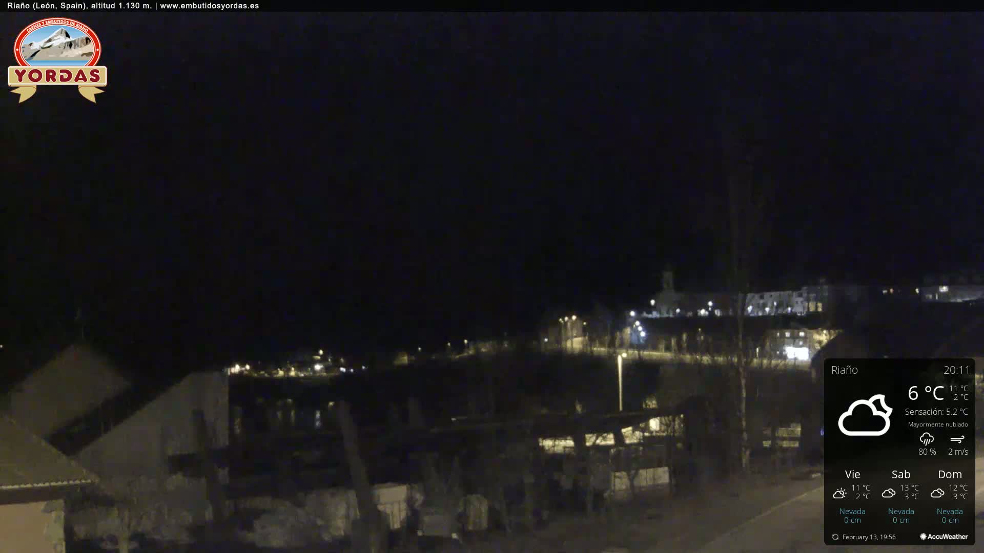 A nighttime view of a town's outskirts under mostly cloudy skies, with a temperature of 6°C.