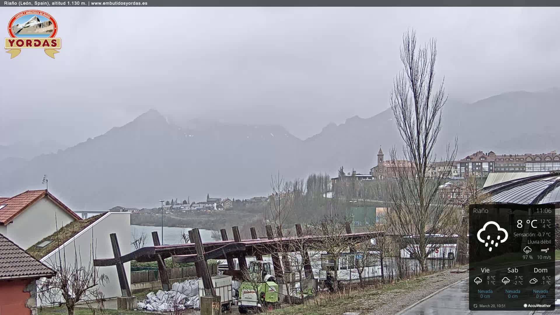 A misty, rainy view of a town nestled in a valley between mountains.