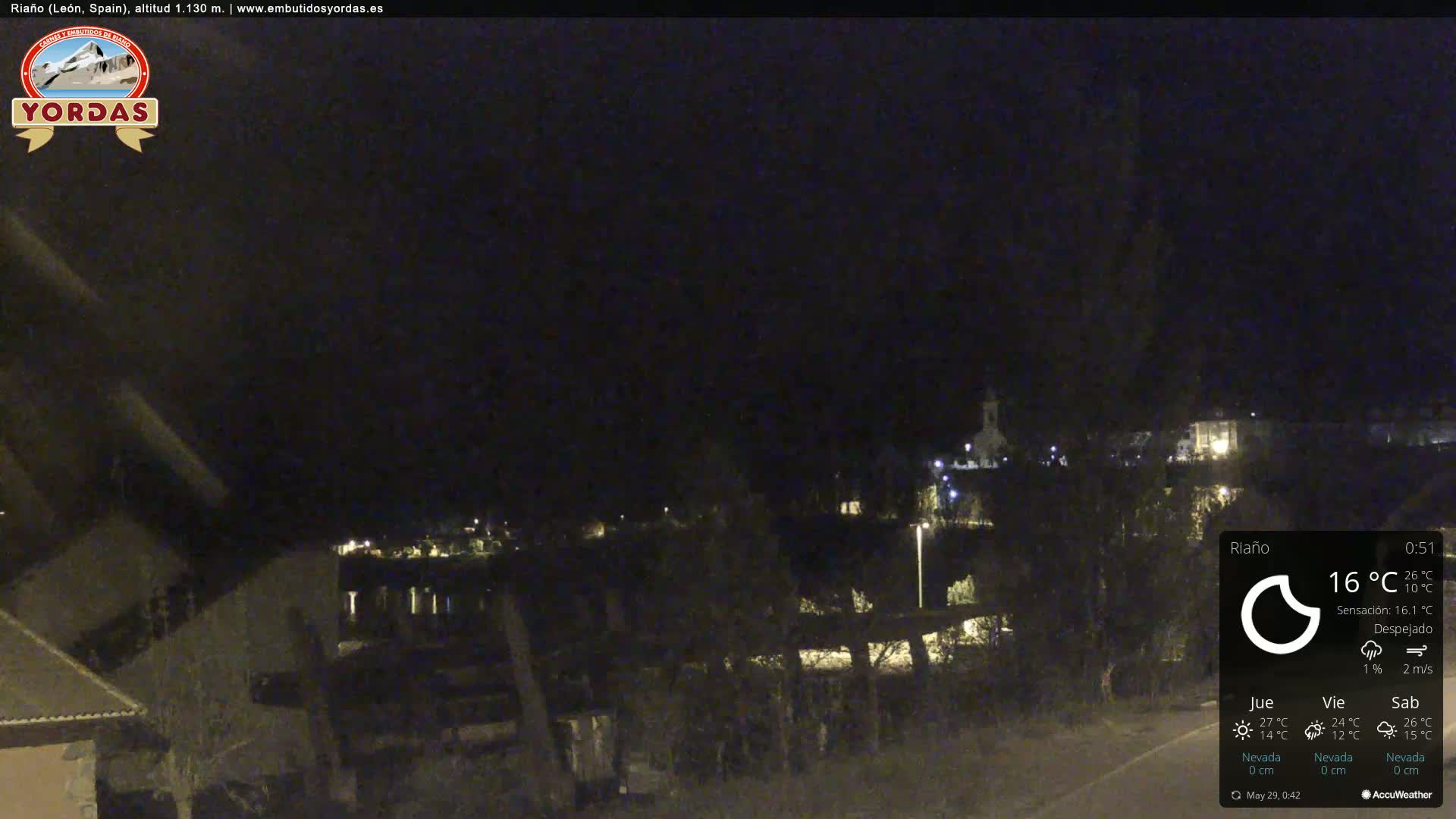 A nighttime view of a small town with scattered lights under a clear, dark sky.