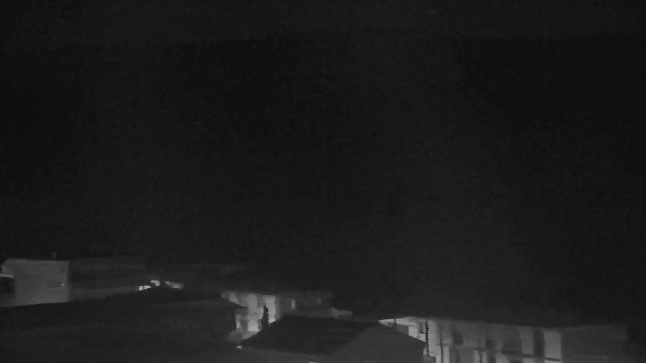 A nighttime, low-light view of a row of houses under a dark sky.