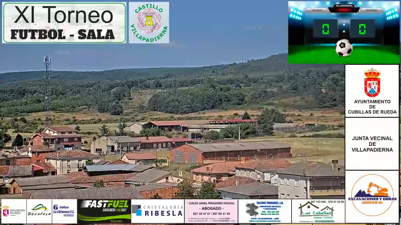 A small town nestled in a verdant valley under a clear blue sky, with a scoreboard showing a 0-0 score in the background.