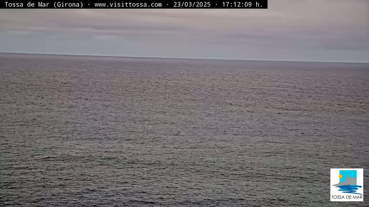 A calm, gray sea stretches to the horizon under an overcast sky.