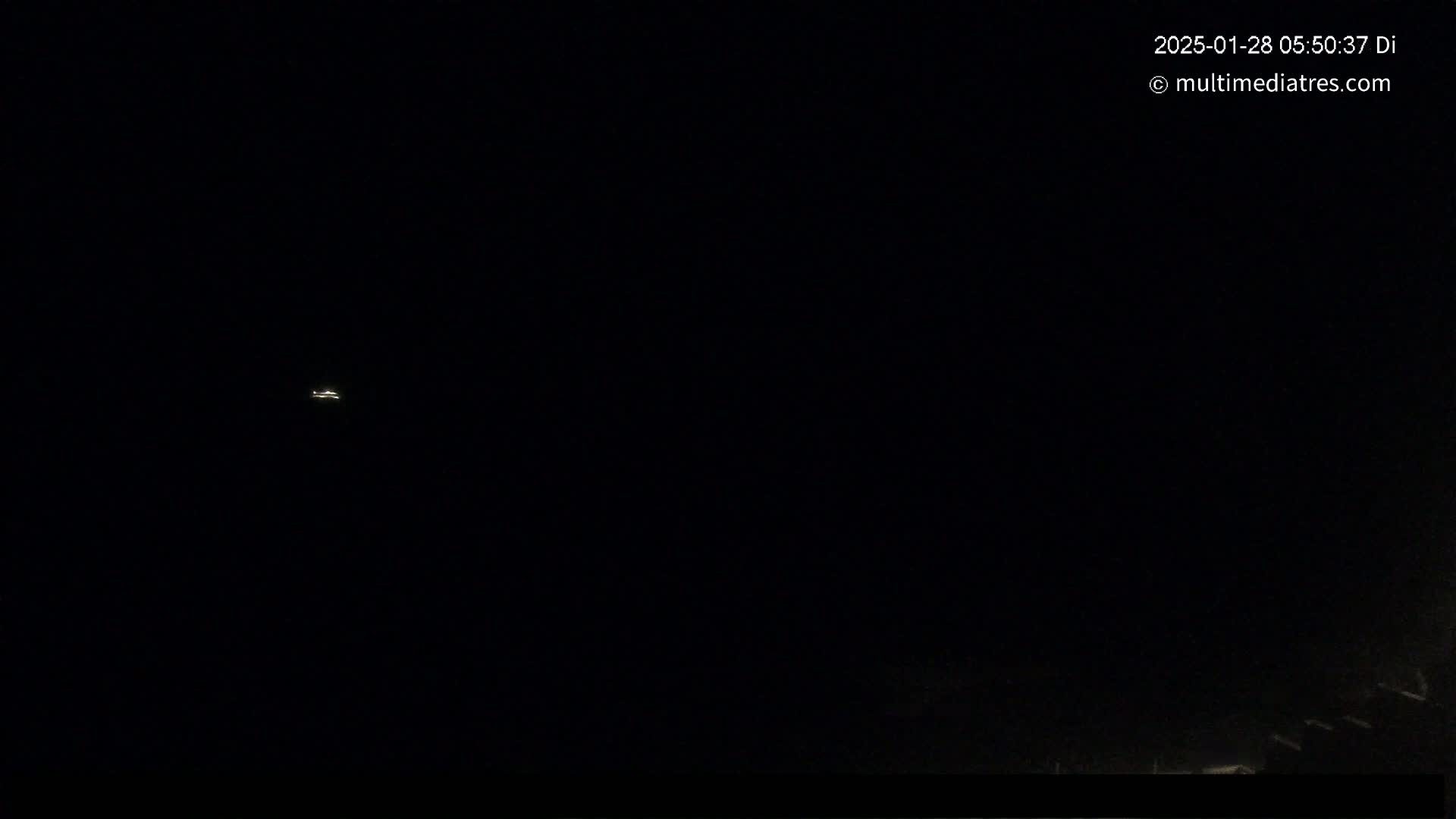 A small light, possibly an airplane, is visible in a dark night sky.