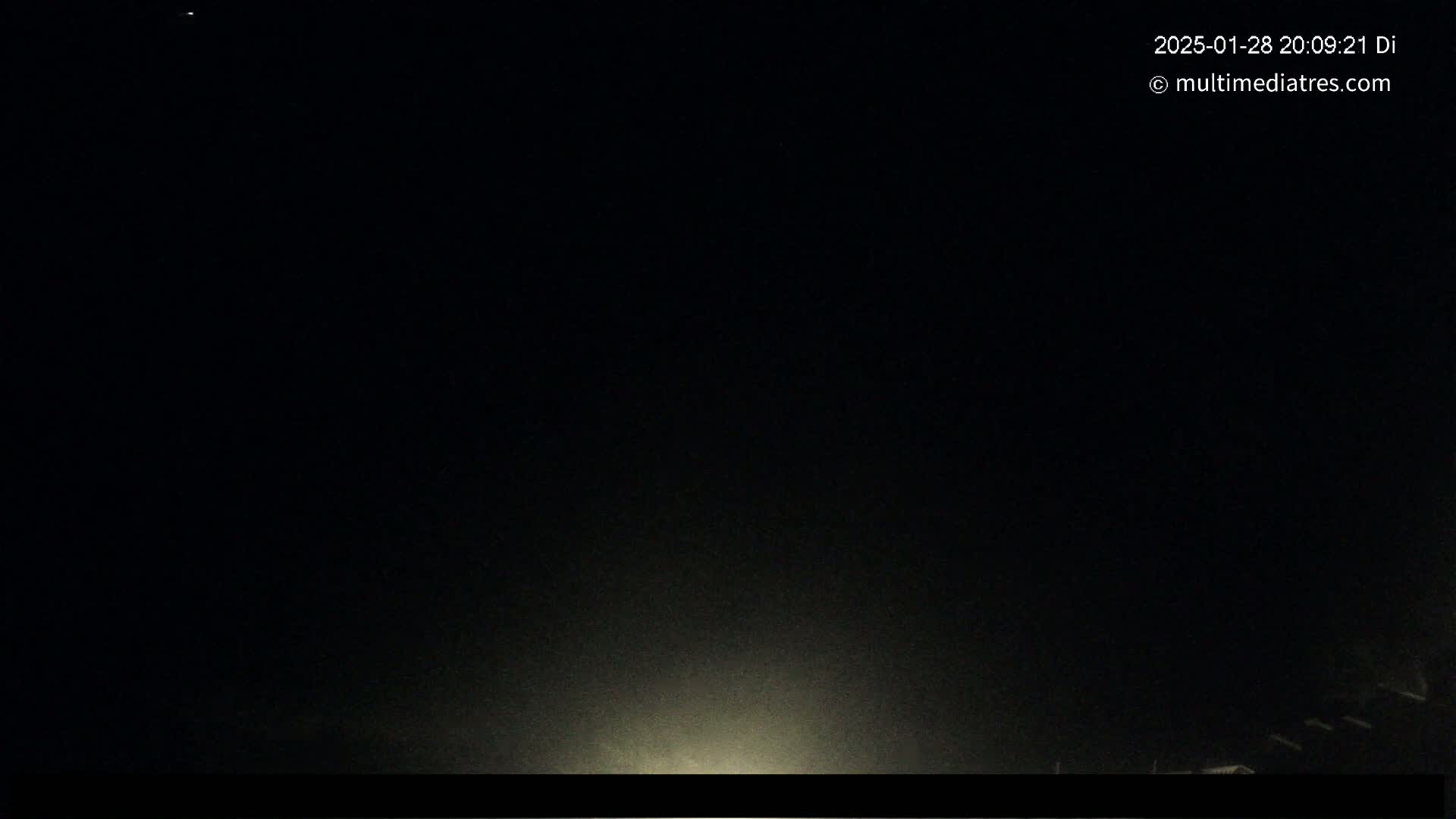 A nighttime, dark scene with a faint light source at the bottom.