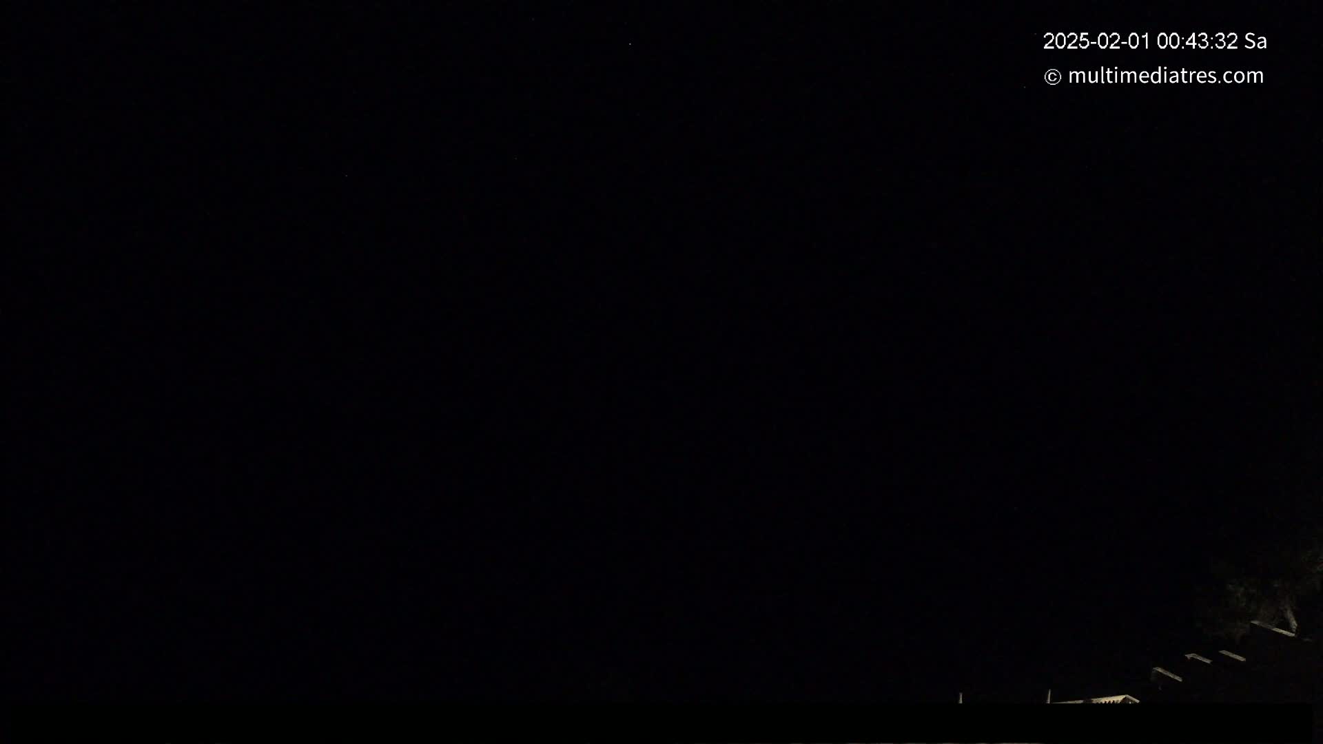 The image shows a nighttime outdoor scene with a dark sky and a very faint hint of vegetation at the bottom edge.