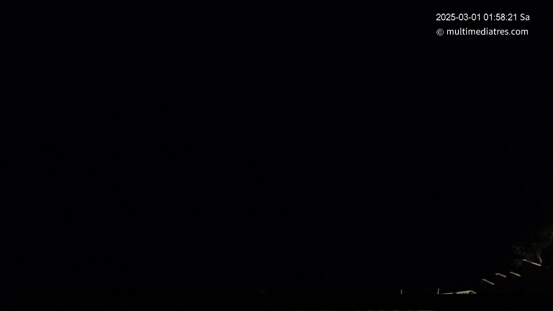 A nighttime, dark image shows faintly lit structures at the bottom edge.