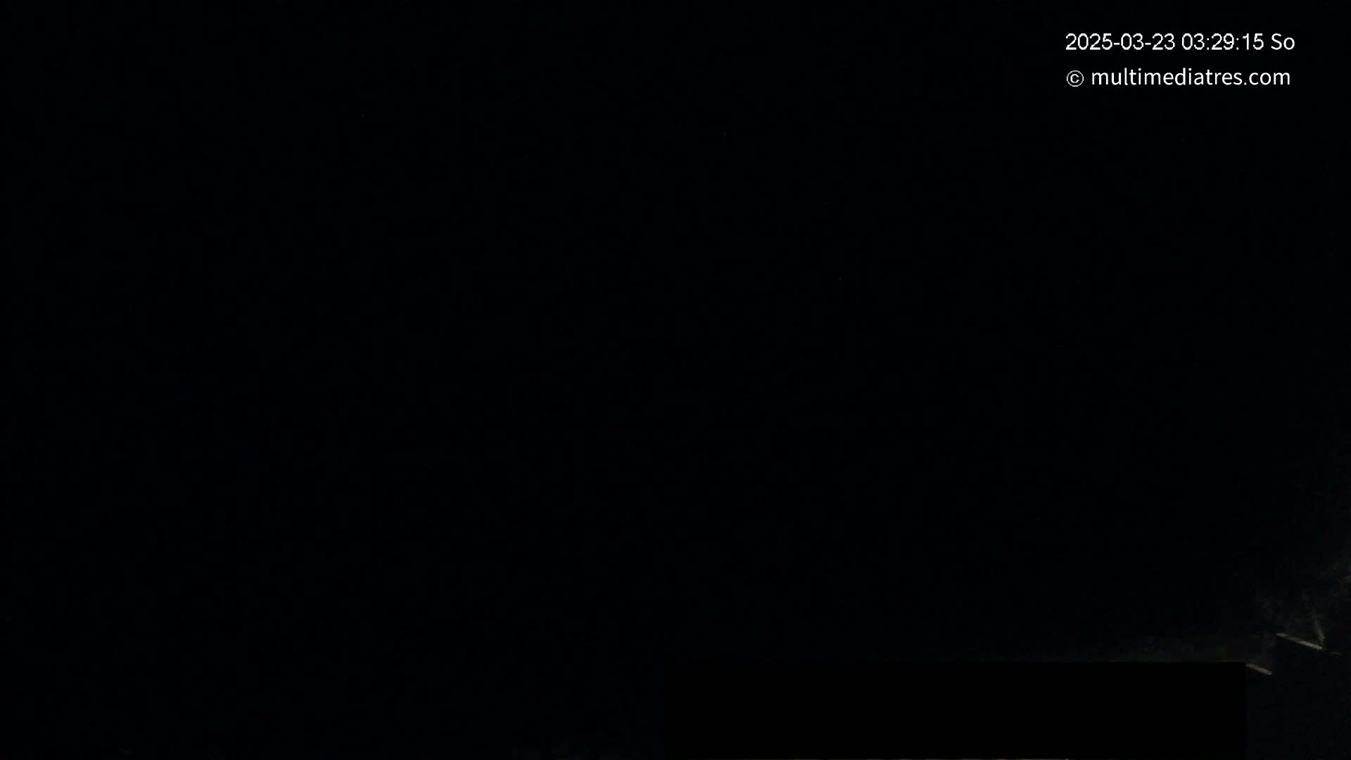 The image shows a mostly black scene at night, with a small, dark rectangle at the bottom.