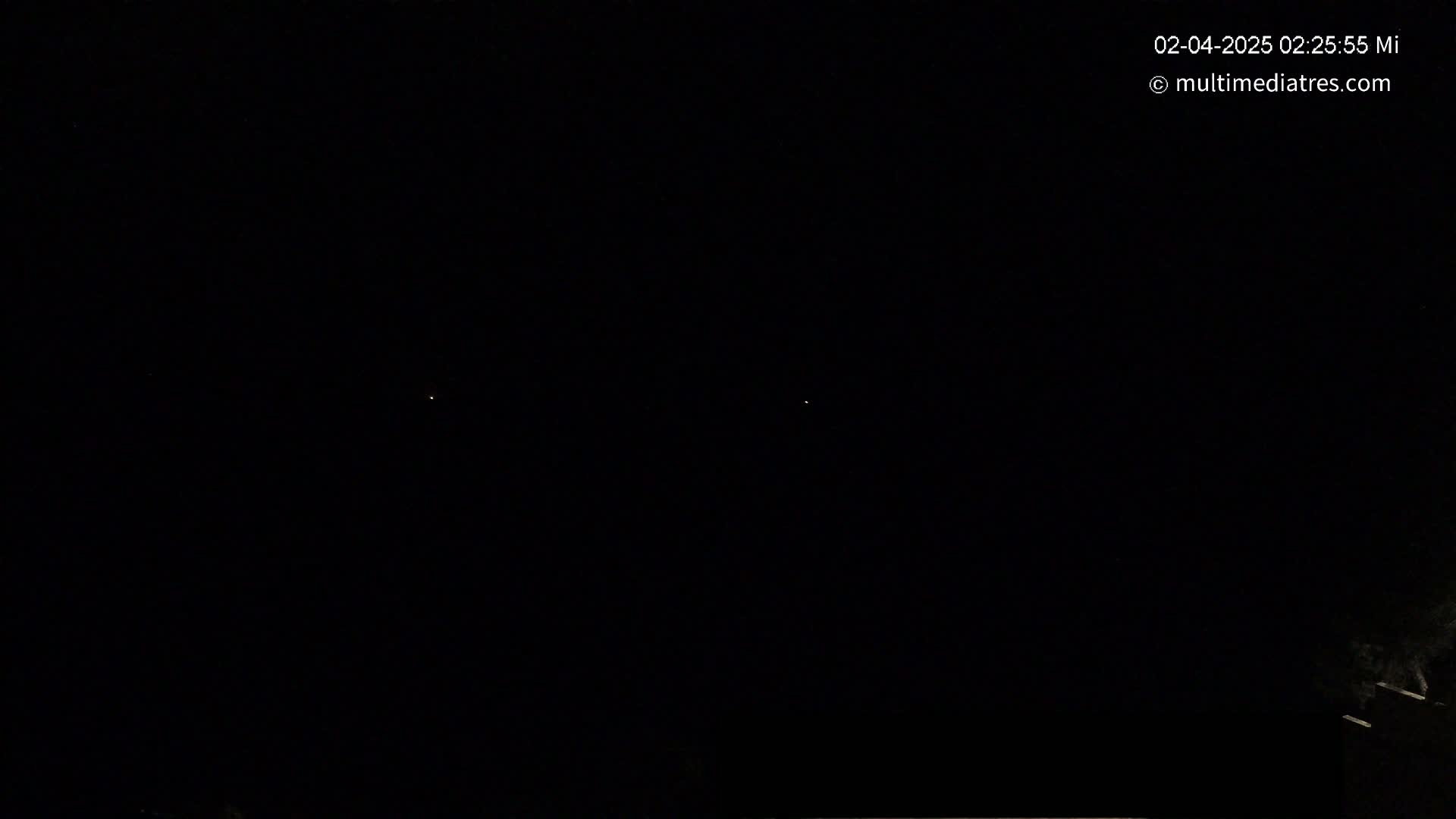 Two faint lights are visible in a dark night sky.