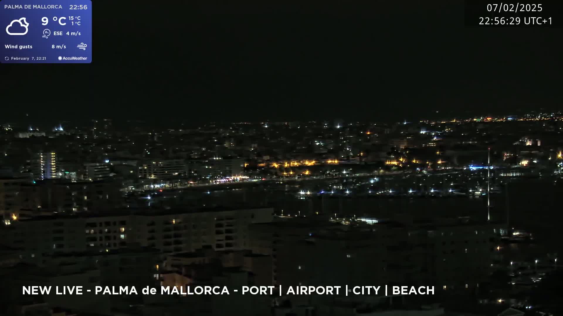 A nighttime view of a city illuminated by scattered lights, under a mostly clear sky.