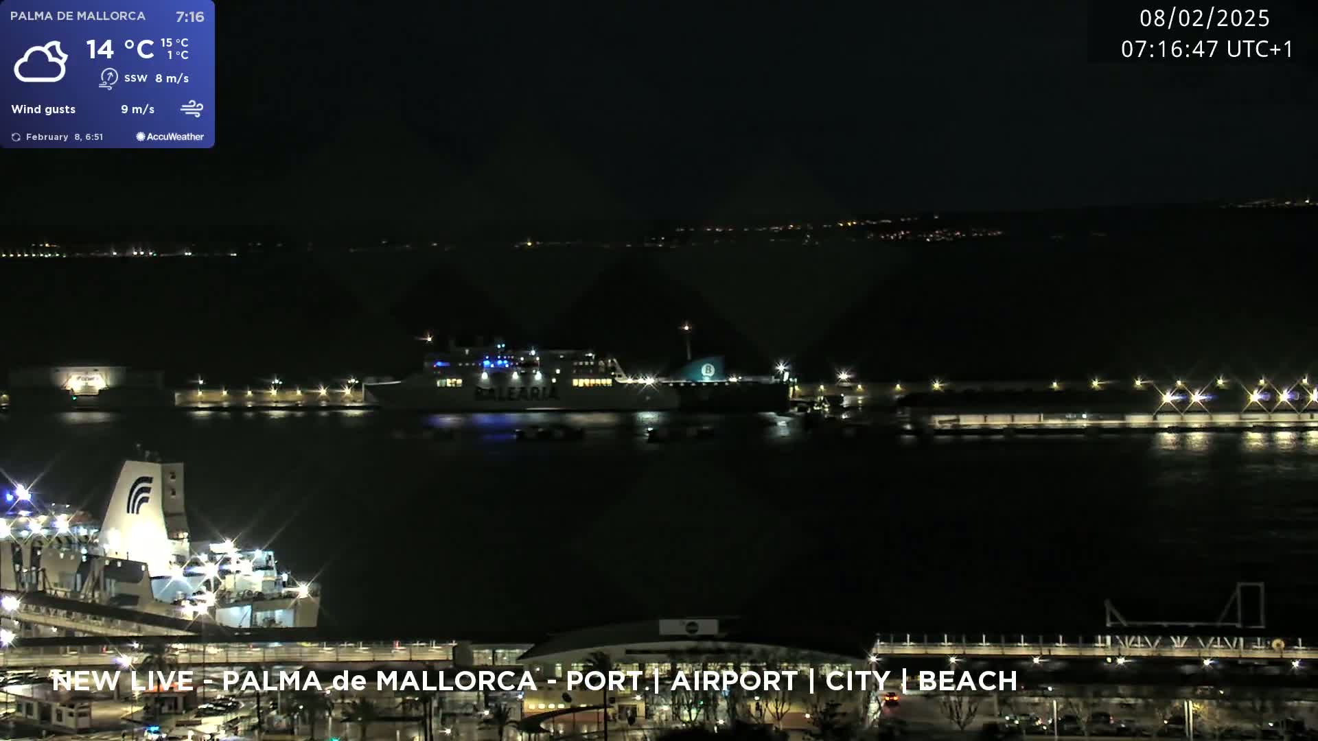 A large ferry is docked at a port at night, under a partly cloudy sky with a moderate wind.