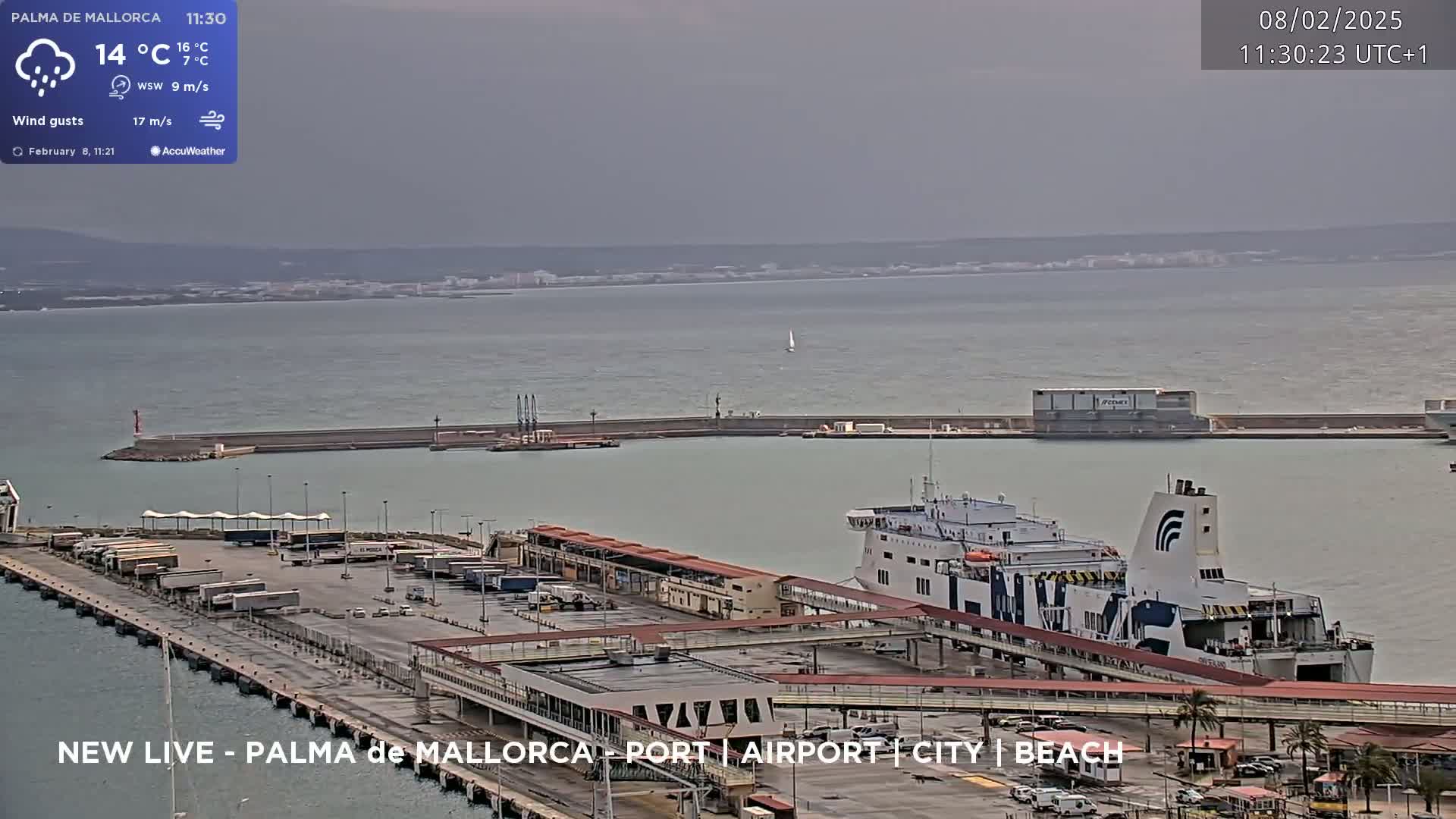 A large ferry is docked at a port on a cloudy day with wind gusts.