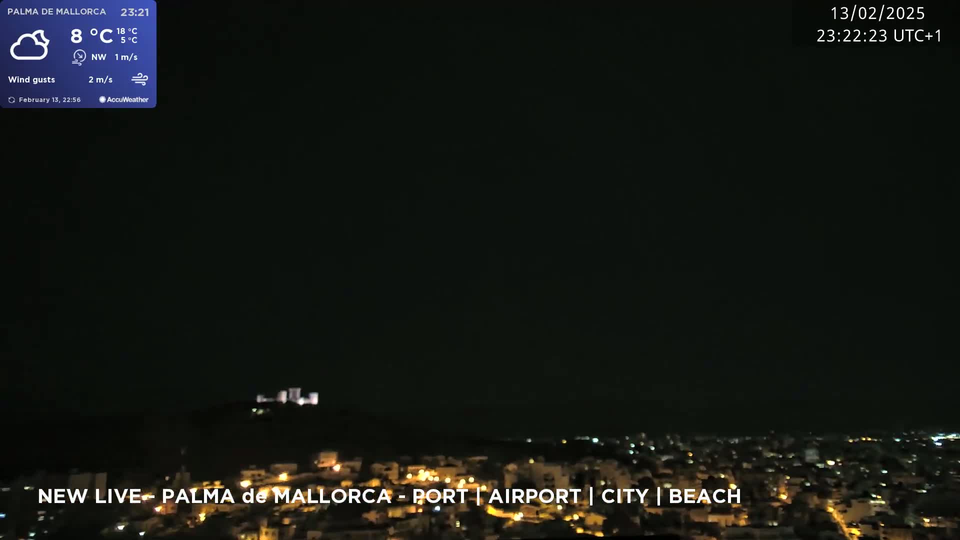 A nighttime view of a city illuminated by lights, under a dark, clear sky.