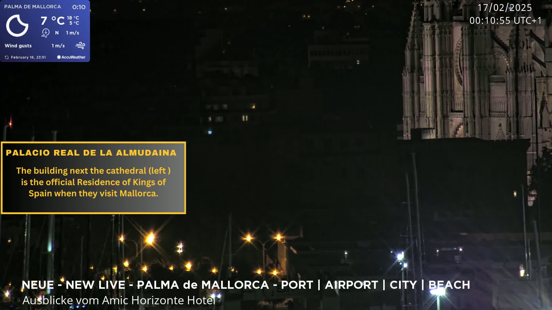 A nighttime view of a city harbor with a large cathedral and other buildings visible, under a clear sky.