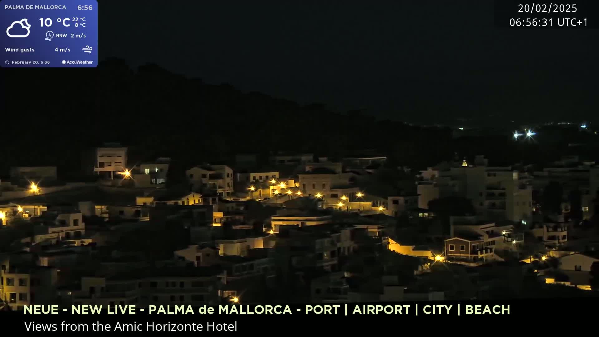 A nighttime view of a town illuminated by streetlights, under a clear, dark sky.