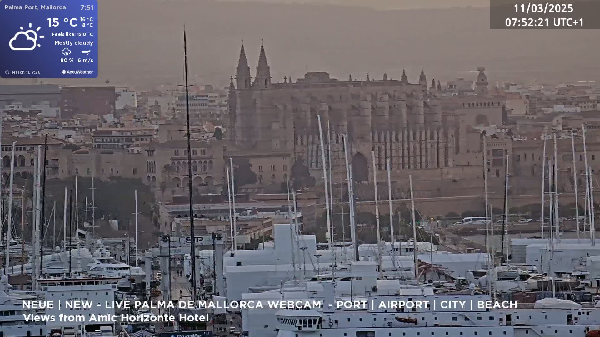 A mostly cloudy harbor scene shows a large cathedral in the background, numerous boats in the foreground, and a hazy atmosphere.