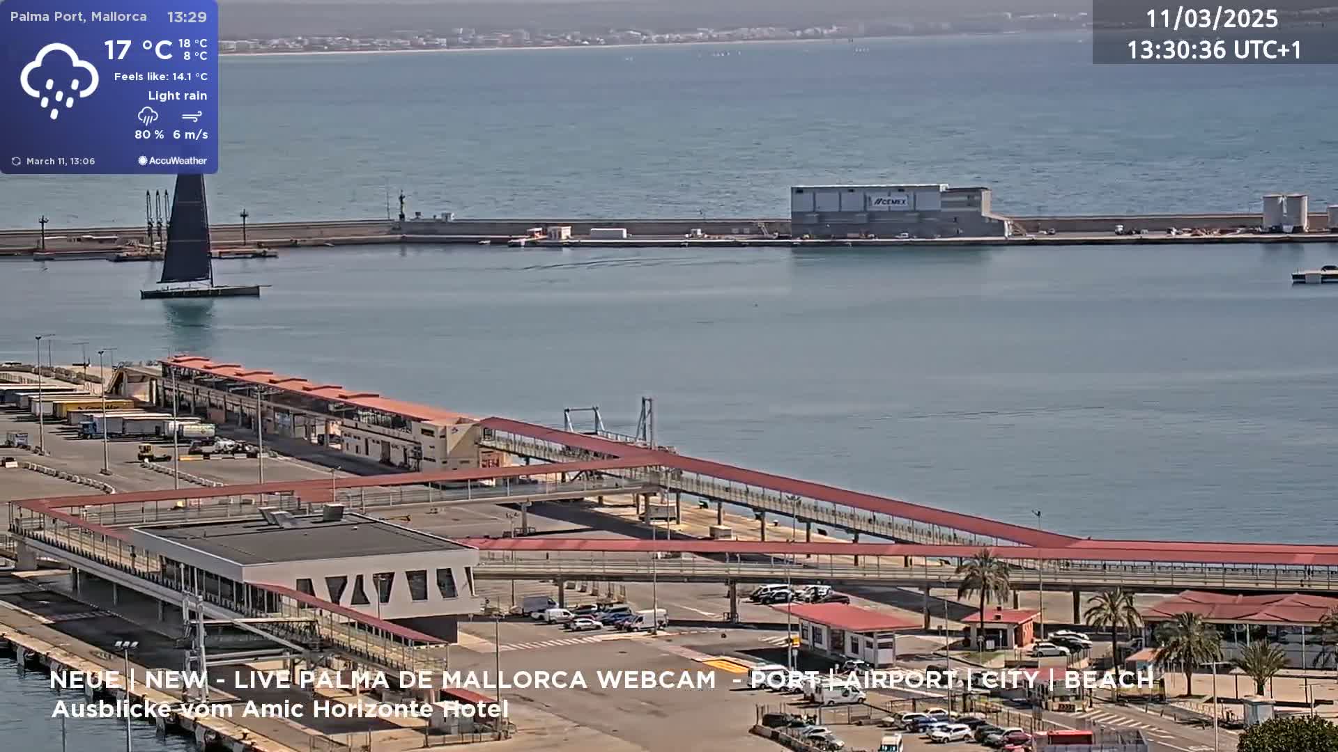 A harbor scene under light rain shows a long pier extending into calm, gray-blue water, with a sailboat and port buildings visible.