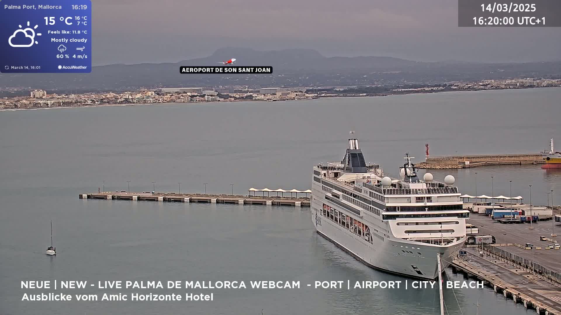 A large cruise ship is docked at a port on a mostly cloudy day.