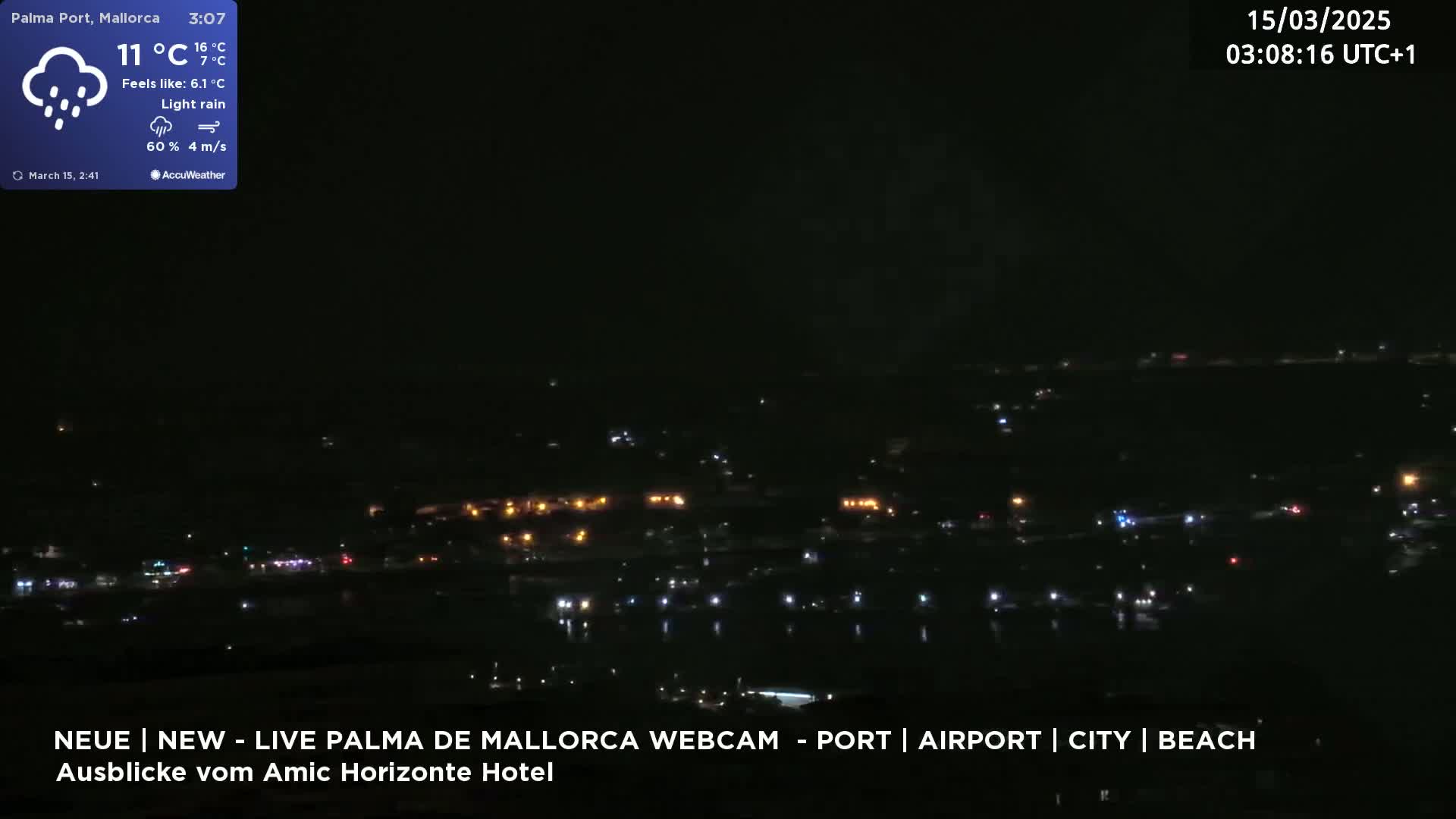 A nighttime view of a city with scattered lights under light rain.