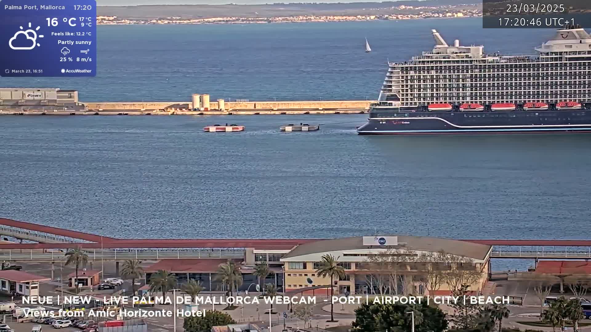 A large cruise ship is docked at a port on a partly sunny day with an 8 m/s wind.