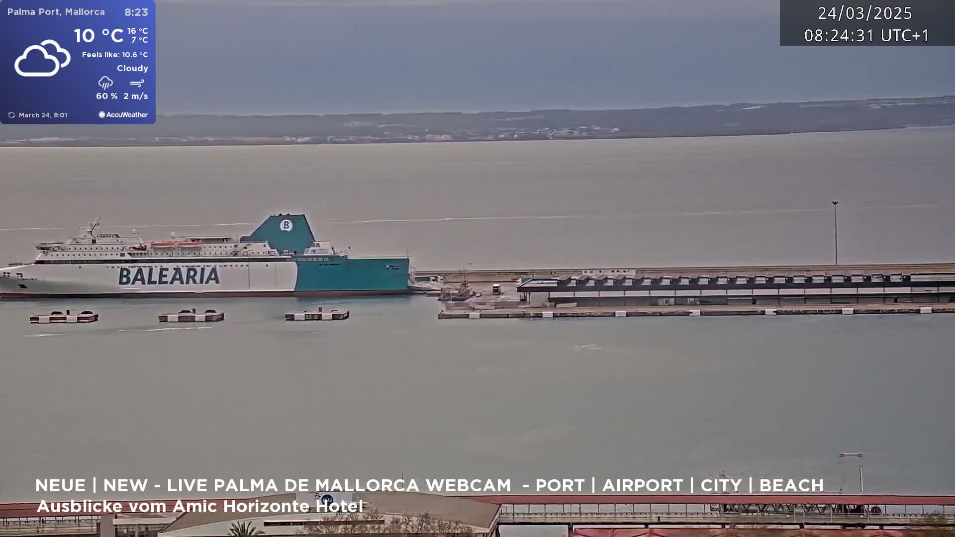 A large ferry is docked at a port on a cloudy day with a light breeze.