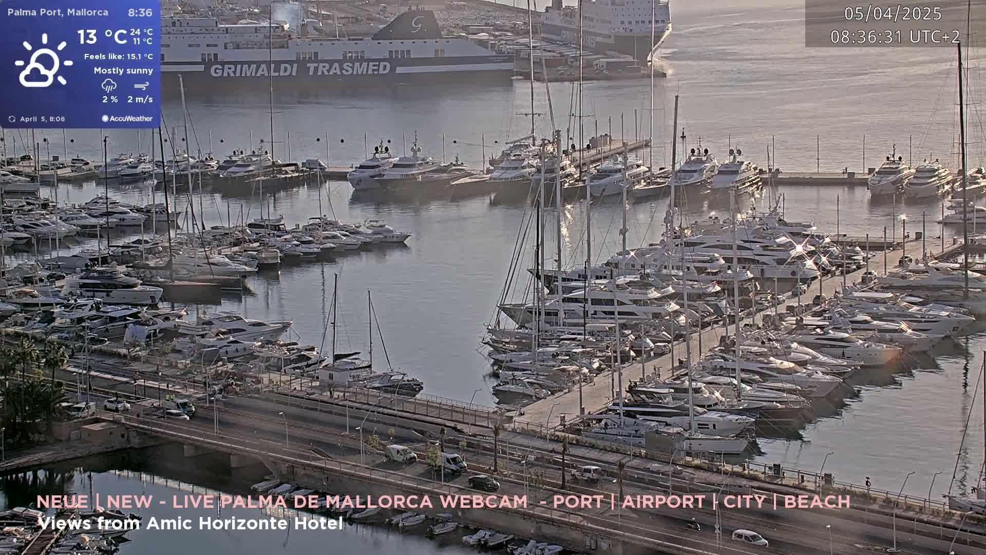 A mostly sunny harbor filled with numerous yachts and boats, under a partly cloudy sky.