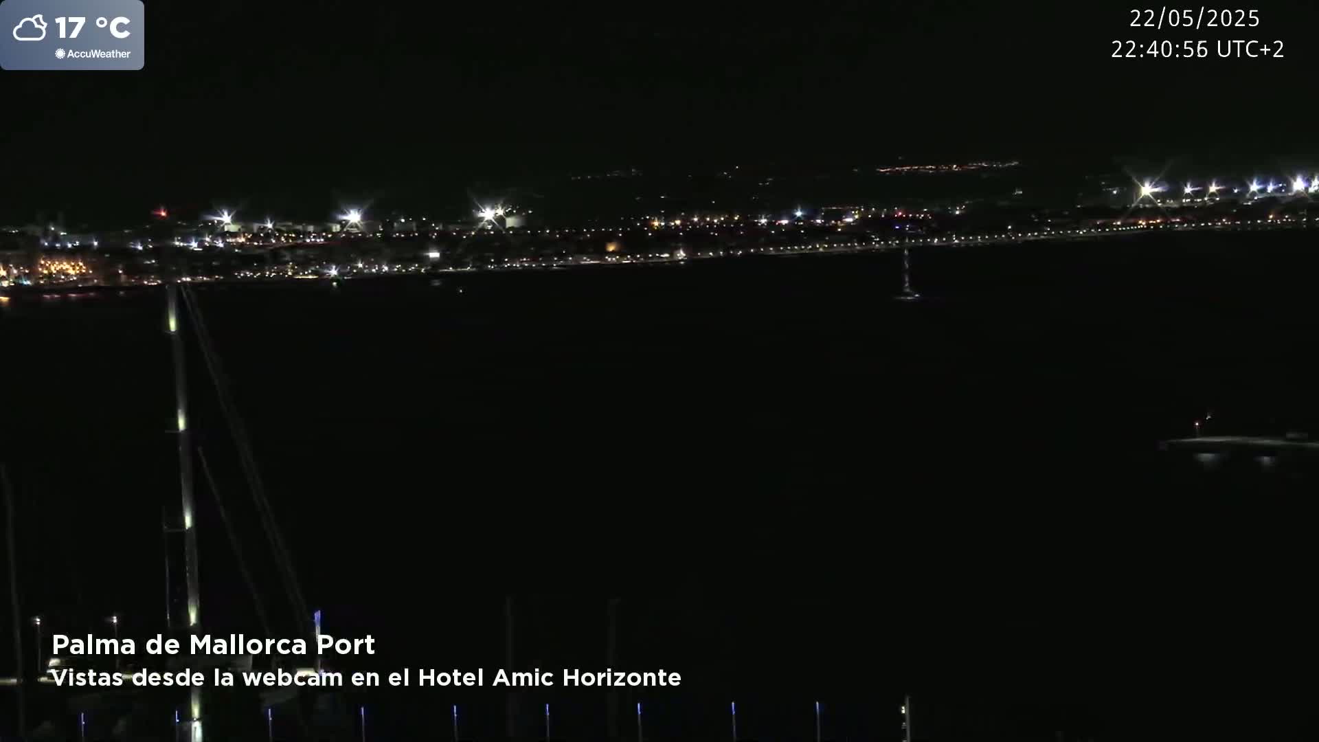A nighttime view of a city's lights across a dark body of water, with a temperature of 17°C.