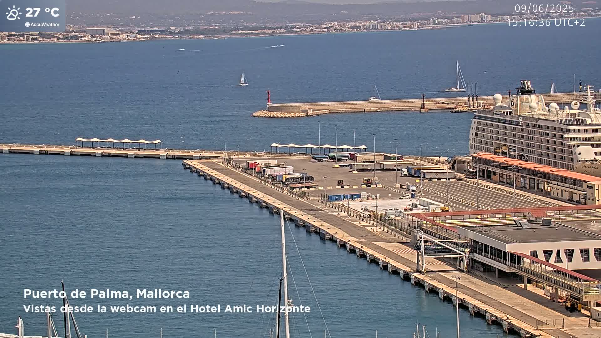 A large cruise ship is docked at a port on a sunny day with calm, blue water.