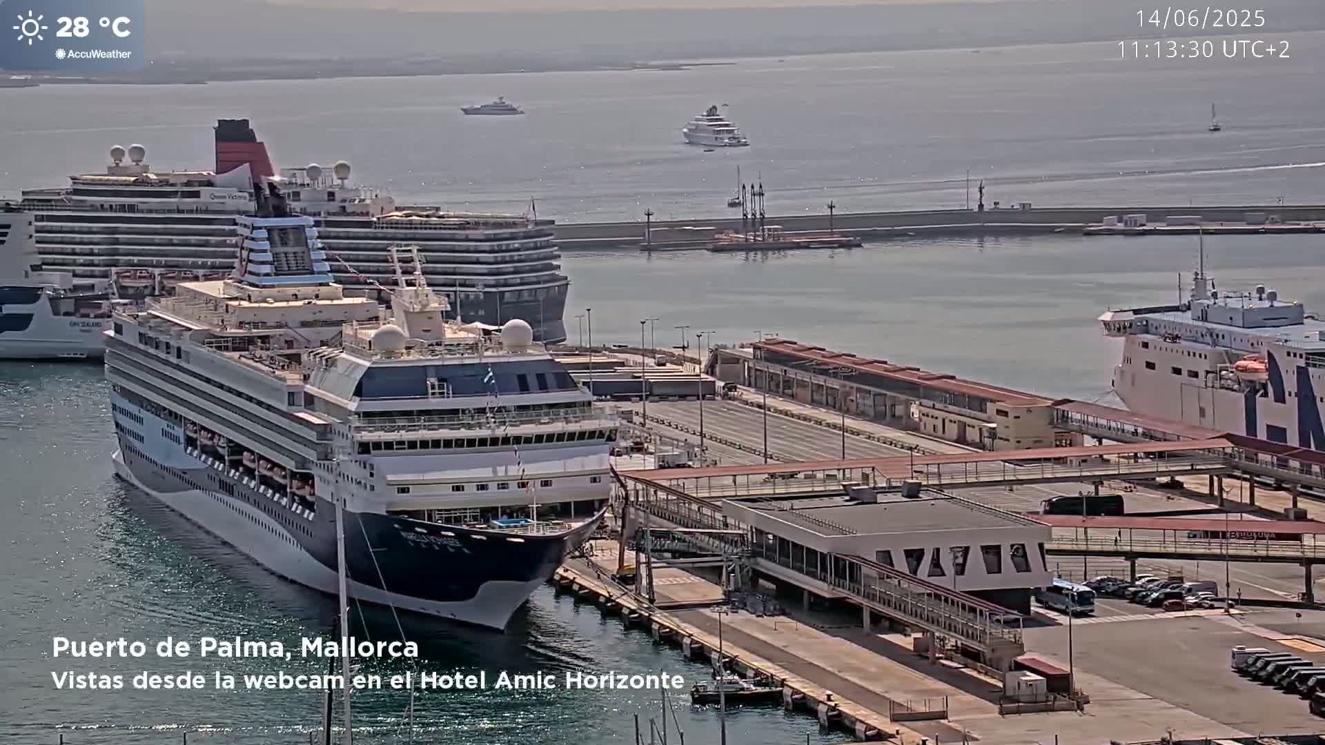 A sunny harbor scene shows several cruise ships and ferries docked at a terminal, with clear skies and calm water.