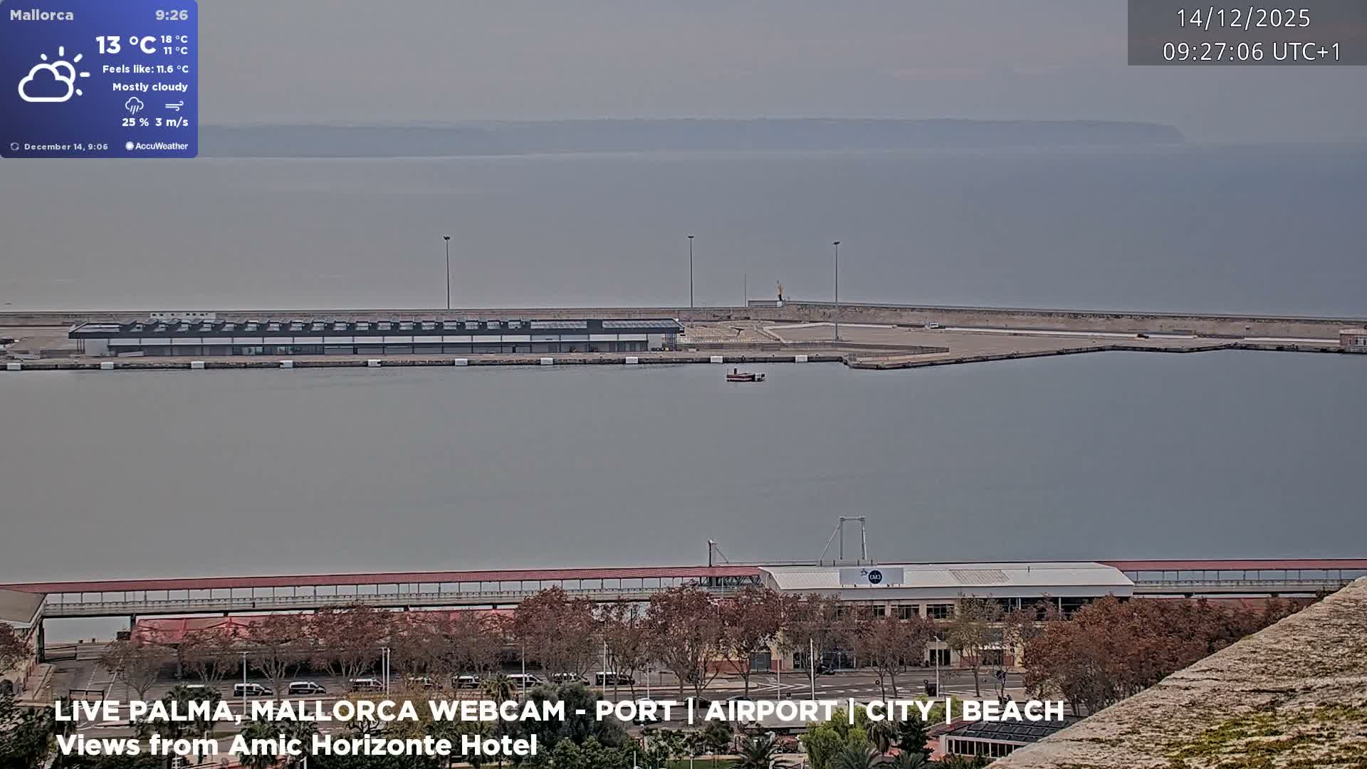 A large cruise ship and a ferry are docked in a bright harbor, with intense sunlight glinting off the water under a hazy, muted sky.
